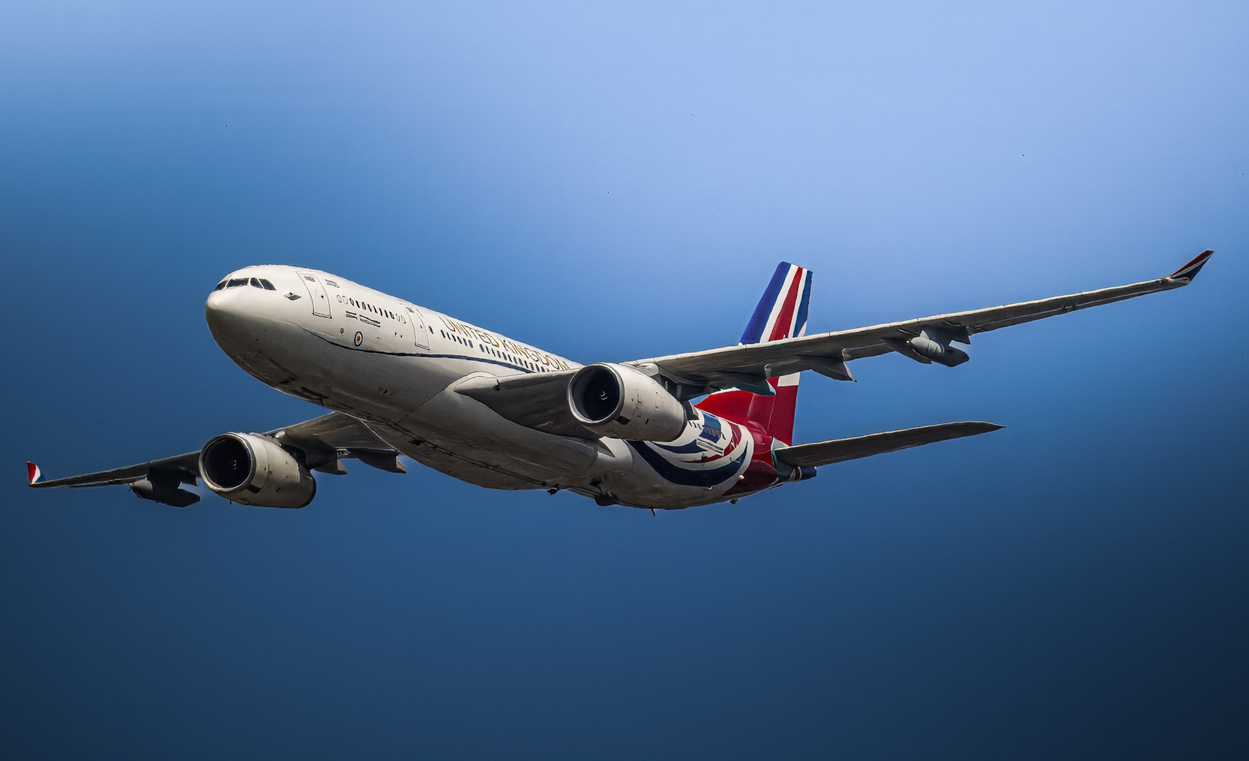 Commercial airplane flying in a clear blue sky representing the cheapest flights booking tips, cheap flight booking hacks, and airfare savings in 2026.